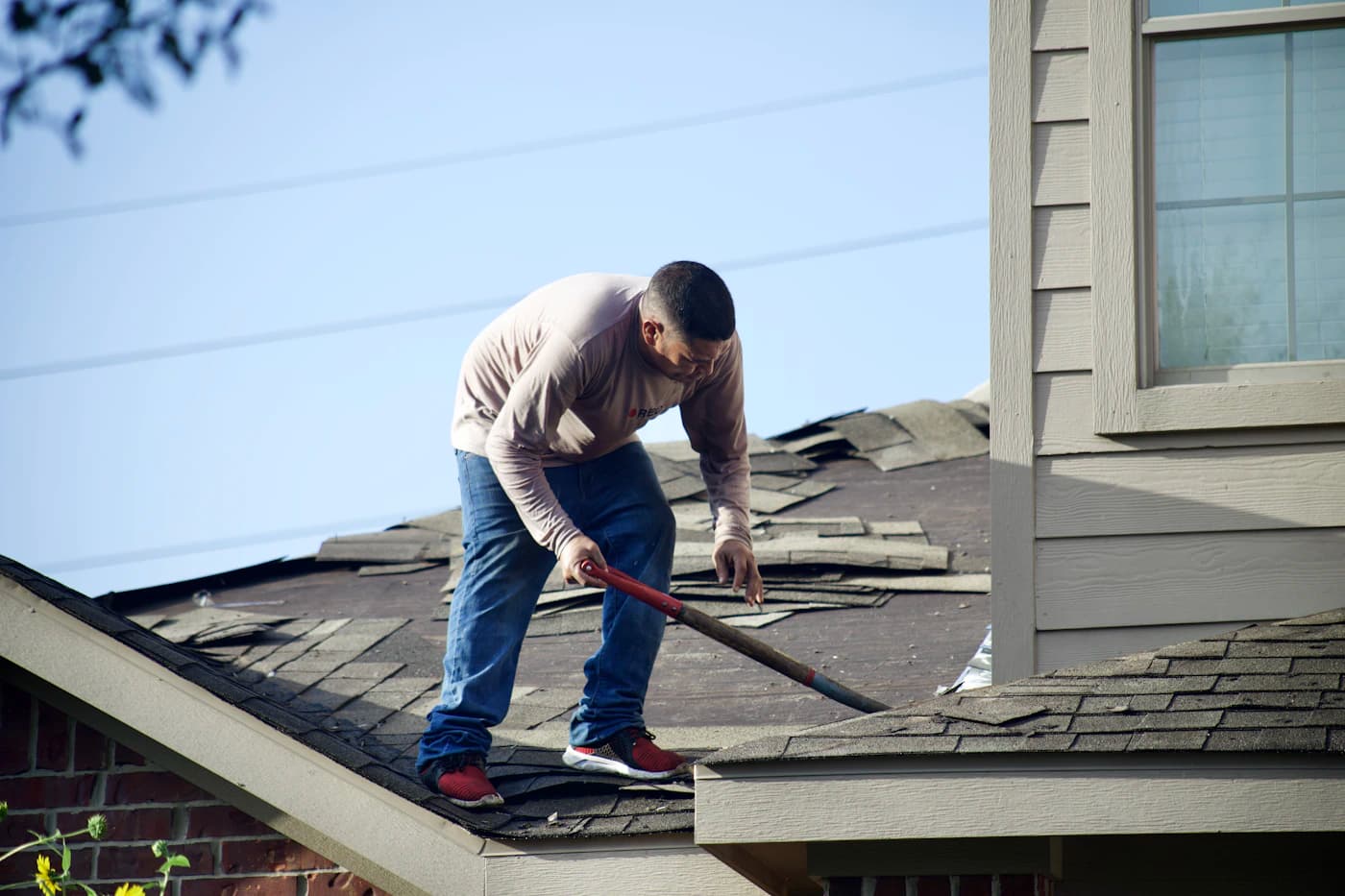 Illustrative roofing work showing removal of old shingles